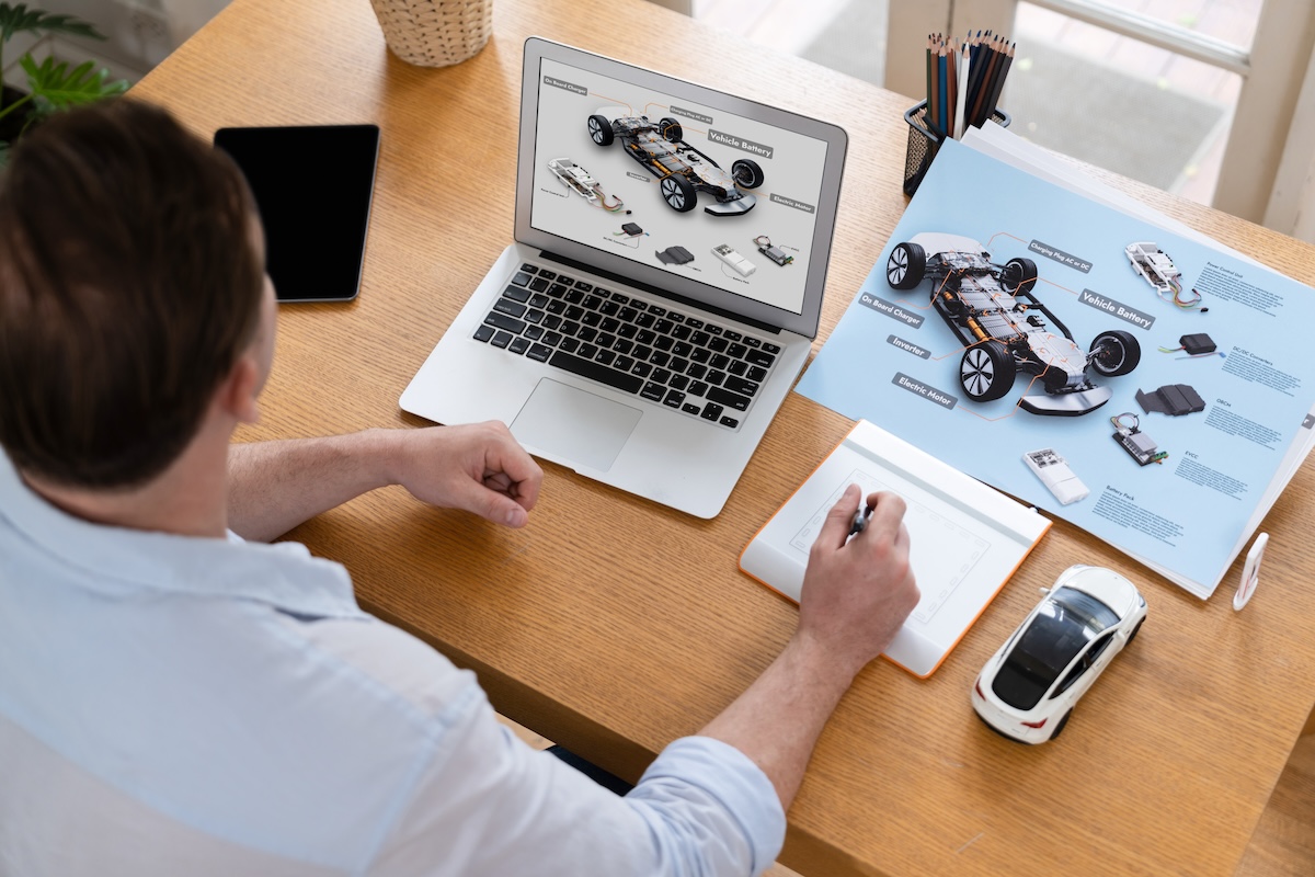 Person designing car on laptop computer