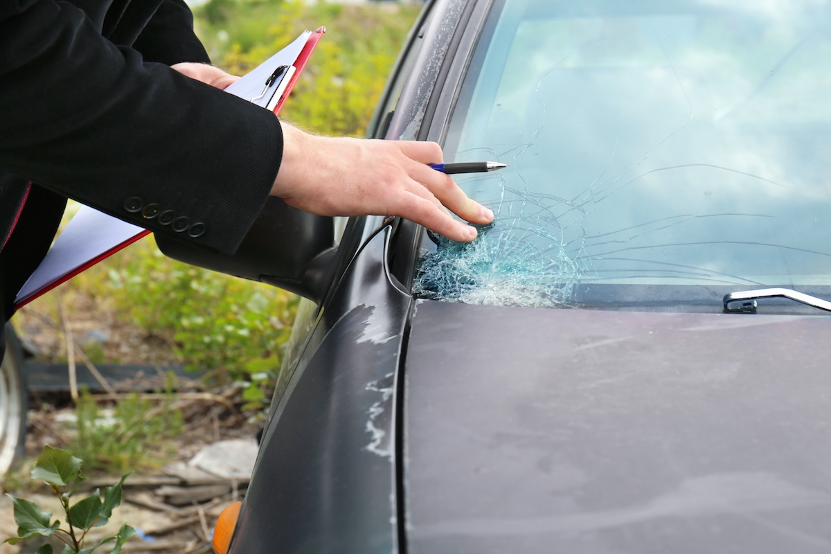 Insurance adjuster examining cracked windshield